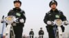 FILE - Police officers secure the area around Beijing's Great Hall of the People, March 3, 2016. Proposed changes to China's police law would give officers more discretion over using firearms. 