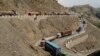 Trucks, stuck for days in Pakistan due to border conflict, travel toward the border post at Torkham, Pakistan June 18, 2016.