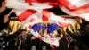 Demonstran mengibarkan bendera saat unjuk rasa memprotes RUU tentang "agen asing" di Tbilisi, Georgia, 13 Mei 2024. (Foto: REUTERS/Irakli Gedenidze)