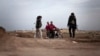 Kurdish female members of the Popular Protection Units check identifications of Kurdish men on a motorbike at a check point near the northeastern city of Qamishli, Syria, March 3, 2013. 