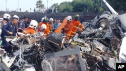 Petugas dari unit pemadam kebakaran dan penyelamatan melakukan pemeriksaan di tempat dua helikopter jatuh di Lumur, negara bagian Perak, Senin, 23 April 2024. (Foto: via AP)
