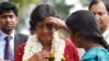 FILE - A Sri Lankan ethnic Tamil girl applies vermillion on the forehead of U.N. High Commissioner for Human Rights Navi Pillay, in red, as she welcomes her at a vocational training center in Kilinochchi, Sri Lanka, Aug. 27, 2013.
