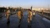 Afghan security forces walk at the site of a suicide attack in Kabul, Afghanistan, Feb. 27, 2016. 