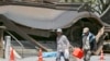 Evacuees walk past the historic Aso Shrine collapsed by powerful earthquakes in Aso, Kumamoto prefecture, Japan, April 17, 2016. 