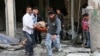 This photo provided by the anti-government activist group Aleppo Media Center (AMC), an anti-Bashar Assad activist group, which has been authenticated based on its contents and other AP reporting, shows Syrian men carrying a covered dead body after a government airstrike attack in the al-Mayssar neighborhood, in Aleppo, April 3, 2014.