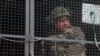 FILE - An Indian army soldier looks from inside an army vehicle at the Indian air force base in Pathankot, India, Jan. 4, 2016.