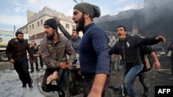 FILE - Syrians carry away the body of a man retrieved from the rubble of a building following a regime airstrike on a vegetable market in Syria's last major opposition bastion of Idlib, Jan. 15, 2020.