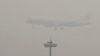 An Air China passenger plane prepares to land at the Beijing Capital International Airport as the capital of China through heavy smog on Wednesday, Dec. 21, 2016.
