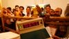 An election official shows an electronic voting machine to poll agents at a counting station in Lucknow, India, March 6, 2012.
