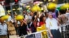 People take pictures behind a cutout of Chinese President Xi Jinping on which pro-democracy protesters put goggles and a yellow ribbon, their symbols, in the part of Mongkok shopping district protesters are occupying in Hong Kong, Oct. 31, 2014.