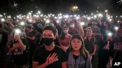 FILE - Demonstrators hold their cellphones aloft as they sing "Glory to Hong Kong" during a rally at Chater Garden in Hong Kong, on Oct. 26, 2019.