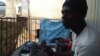 La devanture d’une boutique transformée en habitat à ciel ouvert de quatre jeunes réfugiés centrafricains à Yaoundé. (VOA/Emmanuel Jules Ntap)