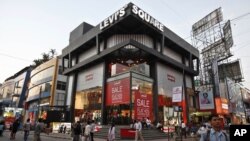 People walk past an American apparel brand store in Bangalore, India, January 11, 2012. 