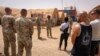 Nesta imagem da Força Aérea dos EUA, o major-general Kenneth P. Ekman fala com militares em frente a um cartaz "Bem-vindo a Niamey" que representa veículos militares dos EUA na Base Aérea 101 no Níger, a 30 de maio de 2024 (arquivo)