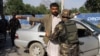 Afghan security personnel search commuters at a checkpoint in Kunduz province on April 15, 2016. 