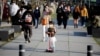 2020年4月3日戴着口罩的女孩在韩国首尔公园骑踏板车。