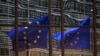 FILE - A European flag reflects in a building of the EU headquarters in Brussels. 