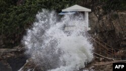 Gelombang yang ditimbulkan oleh Topan Saola pecah di samping menara penjaga pantai di sebuah pantai di Hong Kong pada 1 September 2023. (Foto: AFP)