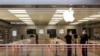 Des employés se tiennent devant l'Apple Store au centre commercial Destiny USA, à Syracuse, New York, États-Unis, le 10 juillet 2020. REUTERS / Maranie Staab