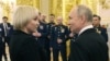Президент Росії поруч з Марією Костюк, матір'ю російського солдата, якого посмертно нагородили орденом "Герой Росії". Цього дня, 8 грудня, Путін оголосив, що балотуватиметься на переобрання у 2024 р. Фото: Mikhail Klimentyev/Sputnik/Pool AFP