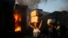 Vendors carry salvaged merchandise from the burned ruins of the Guerite Market that was engulfed in flames in Port-au-Prince, Haiti,vJan. 14, 2020. 