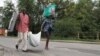 People carry their belongings in Bujumbura, Burundi, Nov. 7, 2015. 