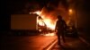 A French anti riot police officer walk past a burning truck in Nantes, western France on early July 1, 2023, four days after a 17-year-old man was killed by police in Nanterre, a western suburb of Paris.