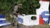 A pro-Russian rebel looks at pieces from the wreckage of the Malaysia Airlines Flight 17 near the village of Rozsypne, eastern Ukraine, Sept. 9, 2014. 
