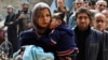 FILE - Residents line up to receive humanitarian aid at the Palestinian efugee camp of Yarmouk, in Damascus, Syria, March 11, 2015. 
