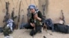 A Kurdish female fighter from Kurdish People's Protection Units [YPG] checks her weapon near Ras al-Ain, in the province of Hasakah, after capturing it from Islamist rebels, November 6, 2013.