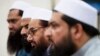 FILE - Hafiz Saeed, second from right, chief of Pakistani religious group Jamaat-ud-Dawa listens to reporters at a news conference in Islamabad, Pakistan, Nov. 2, 2015.