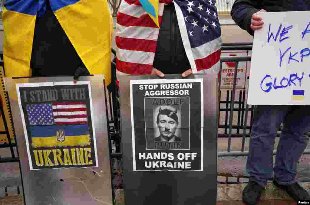 Partidarios de Ucrania sostienen carteles mientras protestan en Washington.