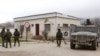 Armed men, believed to be Russian servicemen, stand guard outside a Ukrainian military unit in the village of Perevalnoye outside Simferopol, March 11, 2014.