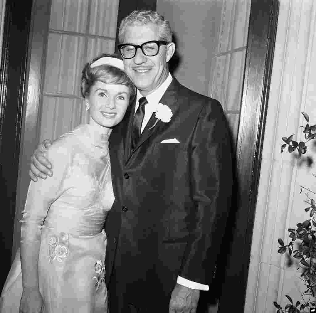 តារាភាពយន្ត Debbie Reynolds អាយុ២៩ឆ្នាំ និងសេដ្ឋីនៃក្រុមហ៊ុនផលិតស្បែកជើងលោក Harry Karl អាយុ៤៦ឆ្នាំ ថតរូបជាមួយគ្នាបន្ទាប់ពីអាពាហ៍ពិពាហ៍របស់ពួកគេនៅទីក្រុង Beverly Hills រដ្ឋកាលីហ្វ័រញ៉ា កាលពីថ្ងៃទី ២៦ វិច្ឆិកា ឆ្នាំ១៩៦០។ អ្នកស្រីគឺជាអតីតភរិយារបស់លោក Eddie Fisher ហើយក៏ជាកូនក្រមុំទី ០៤ របស់លោក Karl។