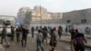 Civilians and Free Syrian Army fighters look into the sky at a site hit by what activists said are barrel bombs dropped by government forces in Aleppo on Nov. 28, 2013.