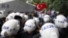 Turkish riot police try to stop ethnic Uighurs from marching to the Chinese Consulate during a protest against China, in Istanbul, Turkey, July 21, 2011.