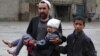 FILE - An Afghan man carries a girl injured in a suicide bomb blast that targeted the Ministry of Defense, in Kabul, Afghanistan, April 19, 2016. 