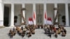 Presiden Joko Widodo (baris atas ke-5 dari kiri) dan Wakil Presiden Ma'ruf Amin (ke-6 dari kiri) bersama menteri-menteri kabinet baru duduk di tangga saat mengumumkan nama menteri-menteri baru, Rabu, 23 Oktober 2019. (Foto: AP)