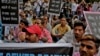 FILE - Sewer cleaning workers and others sit during a protest near the Indian parliament calling for safer working conditions following the deaths of several sanitation employees, in New Delhi, India, Sept.25, 2018.