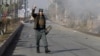 An Afghan policeman reacts as smoke billows during an attack near the Pakistani consulate in Jalalabad, Afghanistan, Jan. 13, 2016. 