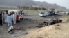 Volunteers stand near the wreckage of a destroyed vehicle, in which Mullah Akhtar Mansoor was allegedly traveling in the Ahmed Wal area in Baluchistan province of Pakistan, near the Afghanistan border, May 21, 2016.