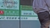 图为一名男子7月22日走过香港股票交易所