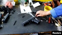 A weapons designer picks up a prototype of a handgun at the manufacturing hall in the "Zastava Arms" weapons factory in the Serbian town of Kragujevac, some 137km (85 miles) from capital Belgrade, May 8, 2013.