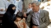 U.N. High Commissioner for Refugees Filippo Grandi talks to an Afghan refugee woman during his visit to the UNHCR's Repatriation Center in Peshawar, Pakistan, June 23, 2016.