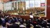 FILE - In this file photo released by the Extraordinary Chambers in the Courts of Cambodia, court officers of the U.N.-backed war crimes tribunal are seen through windows during a hearing of former Khmer Rouge top leaders in Phnom Penh, Cambodia. 