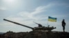 FILE - A Ukrainian soldier stands guard near a tank position close to the Russian border near Kharkiv.