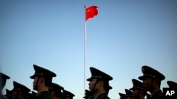 FILE - Chinese paramilitary police stand in formation after a flag raising ceremony at Tiananmen Square on National Day. News of Lei Yang’s death in police custody in May sparked a national outcry, with many voicing concerns online about police brutality and abuse of power. 