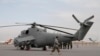 FILE - An Afghan soldier walks past Indian-donated helicopters to Afghanistan at the Kabul airport in Kabul, Afghanistan, Dec. 25, 2015.