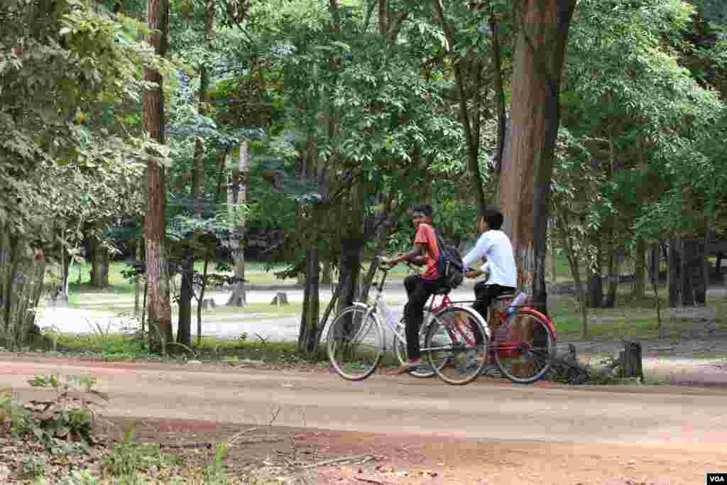 កុមារា​ពីរ​នាក់​ជិះ​កង់​លើ​ផ្លូវលំ​មួយ​នៅ​ក្នុង​បរិវេណ​តំបន់​ប្រាសាទ​សំបូរ​ព្រៃគុក​ កាល​ពី​ថ្ងៃ​ទី​១៣​ ខែ​កក្កដា​ ឆ្នាំ​២០១៧។ (ស៊ុន ណារិន/VOA)