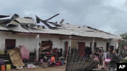 Mwanamume akitembea karibu na jengo lililoharibiwa na kimbunga Freddy tarehe 22, Februari 2023, baada ya kimbunga hicho kutua Madagaska. Picha na AP/Solofo Rasolofomanana.